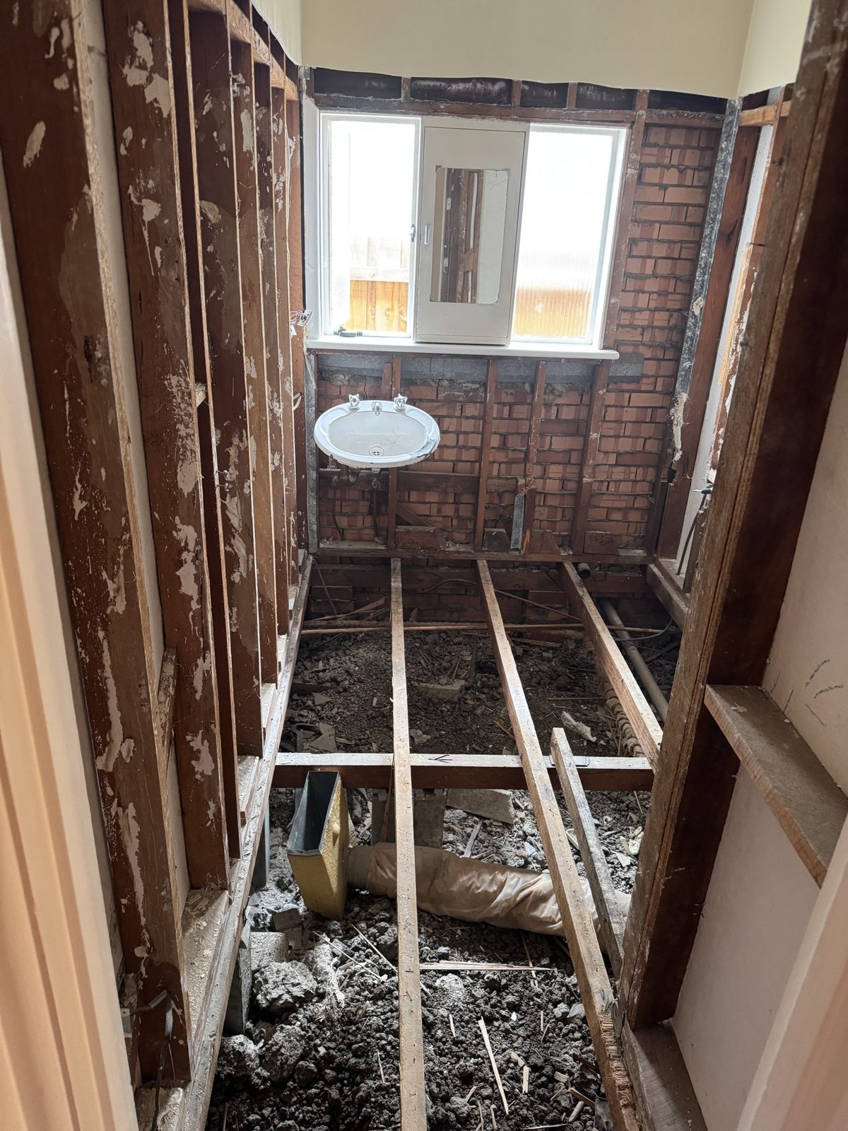 Floor joists exposed during the bathroom strip-out, ready for the subfloor to be dropped