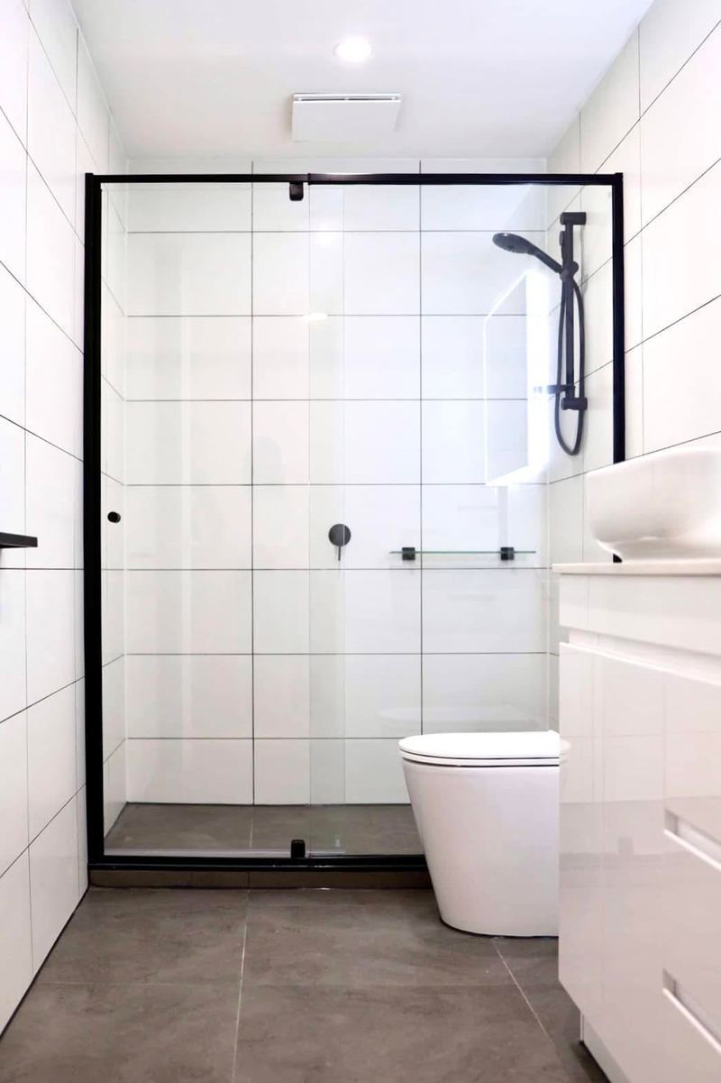 Bathroom with black-framed shower screen and white square tiling