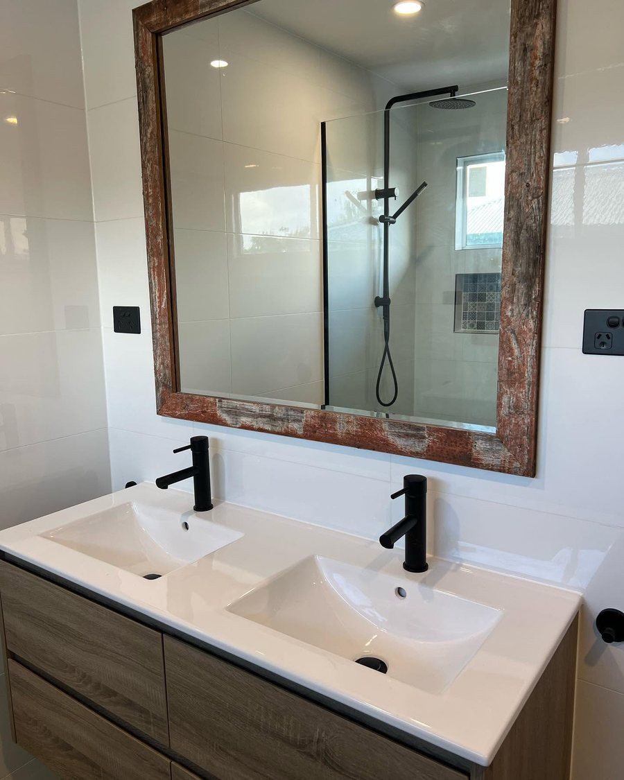Bathroom with double vanity and exposed brick feature wall