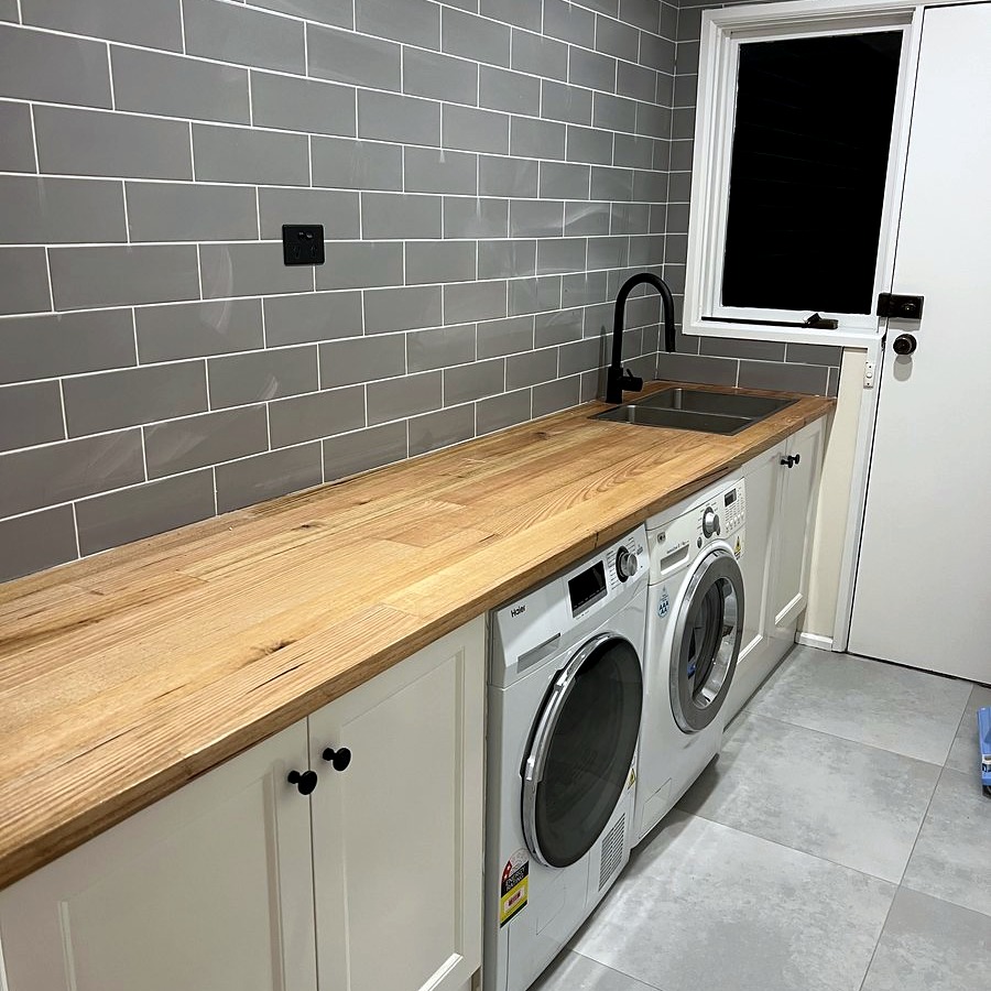 Bathroom renovation with herringbone tile and black tapware