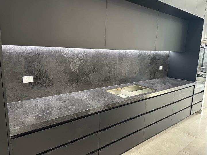 Custom handleless cabinetry with stone splashback