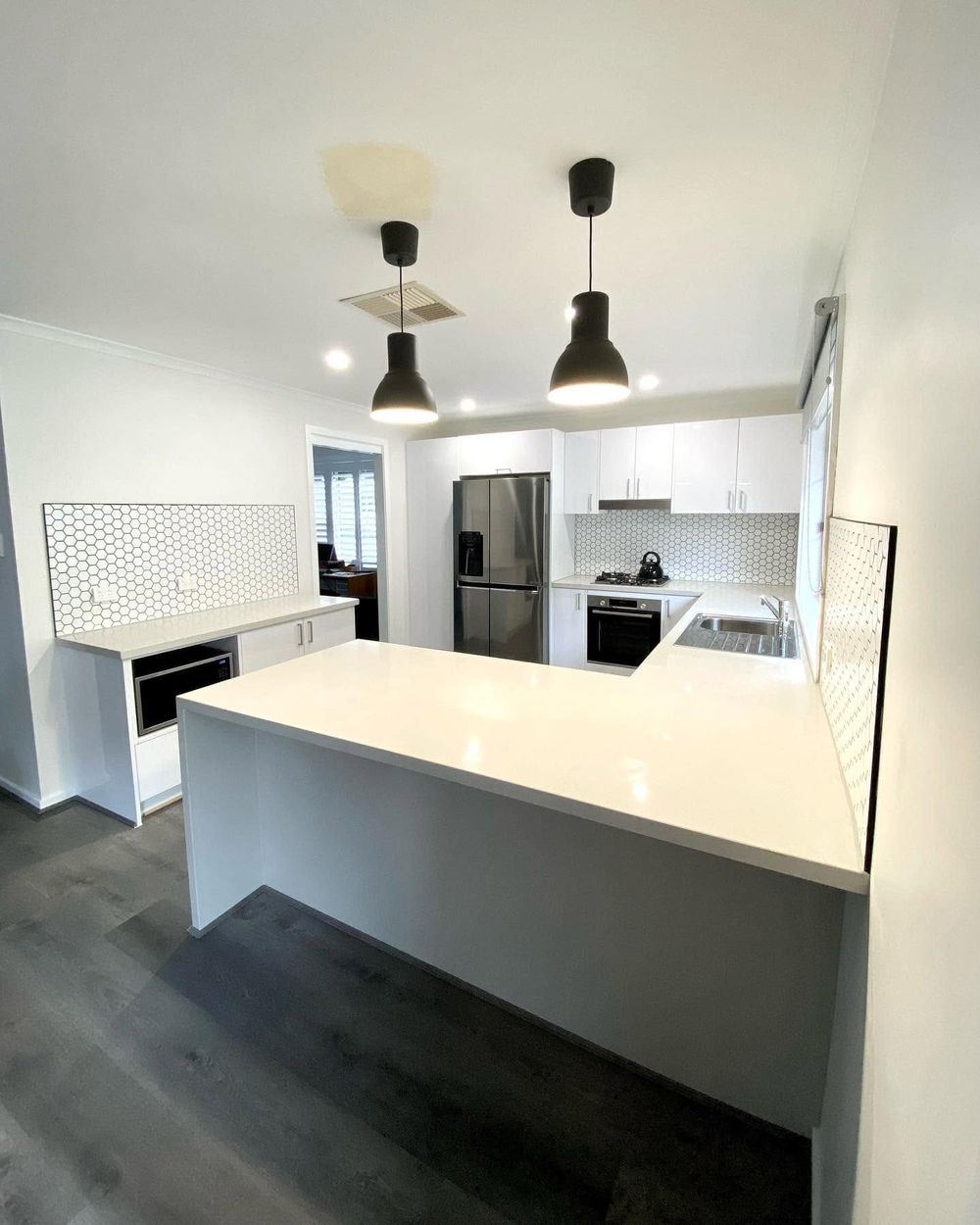 Renovated kitchen with a white island bench and pendant lighting