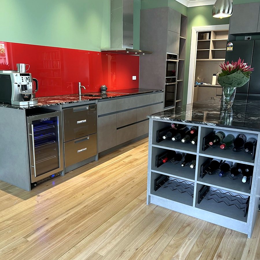 Kitchen renovation with bold red splashback and wine fridge
