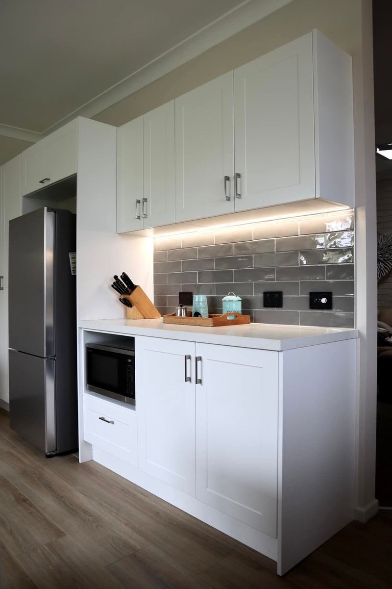 Kitchen renovation with white shaker cabinetry and under-cabinet lighting