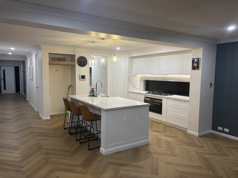 Open plan kitchen with island seating and herringbone timber flooring